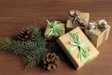 Christmas. On a brown background boxes wrapped in paper and decorated with bows. The boxes of Christmas presents. Near two pine cones.