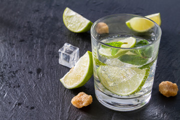 Mojito and ingredients, dark stone background