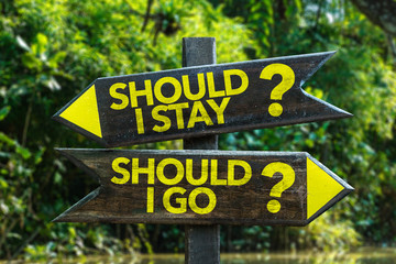 Should I Stay? Should I Go? signpost with forest background © gustavofrazao