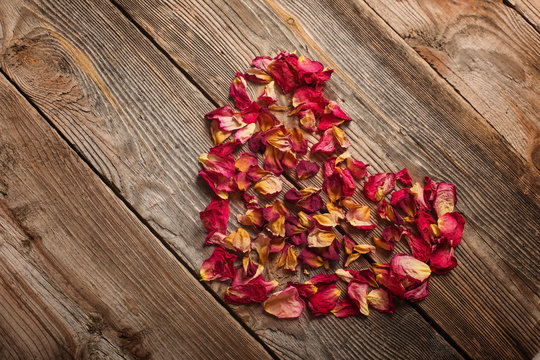 dried rose petals on wooden table