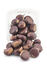 Box or punnet and spilled fresh organic chestnuts isolated on white background
