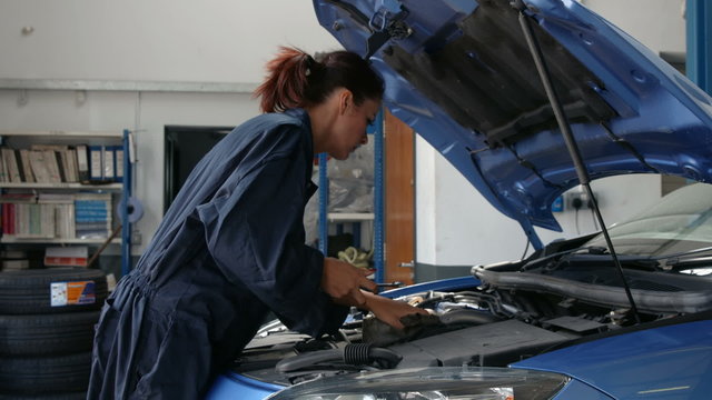 Female mechanic overhauling an engine