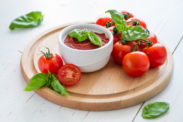 Tomato sauce and ingredients on white wood background