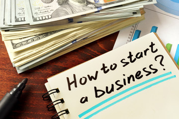 Notepad with how to start a business on the wooden table.