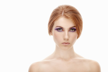 Closeup beauty portrait of a young beautiful redhead woman with violet eyes makeup on  isolated background