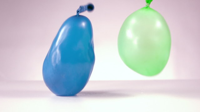 Blue and green water balloon falling