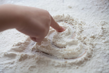 Heart of flour on wooden desk painted by a child