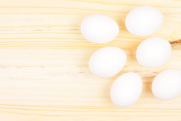Six White Egss on Wooden Chopping Board