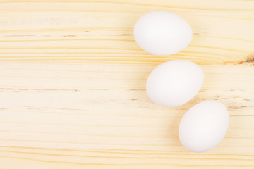 Three White Eggs on Wooden Chopping Board
