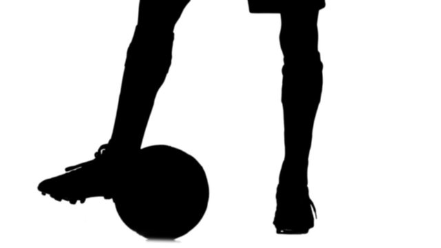 Silhouette of football player controlling the ball 