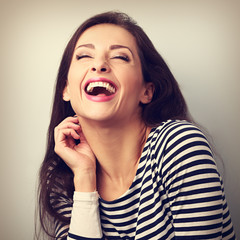 Laughing young casual woman with wide open mouth and closed eyes