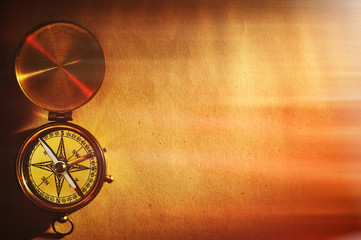 Antique brass compass over old background