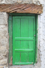 Puerta verde con candado en pared encalada