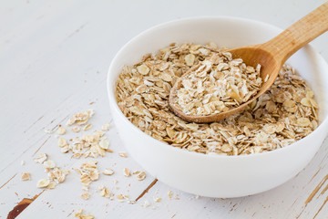 Oat meal in white bowl, wood background