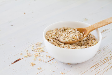 Oat meal in white bowl, wood background