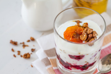 Granola and ingredients, white wood background