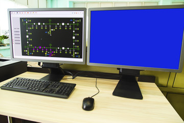 Computers and monitors with schematic diagram for supervisory, control and data acquisition in modern electrical control room