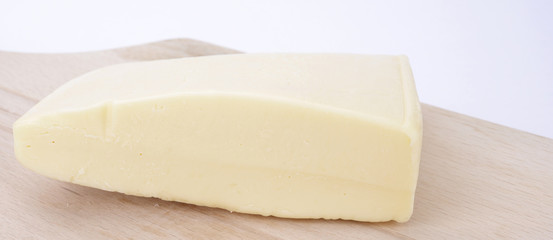 Yellow cheese over wooden board