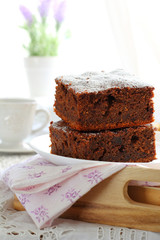 two pieces of plum cake with chocolate and almonds on a tray