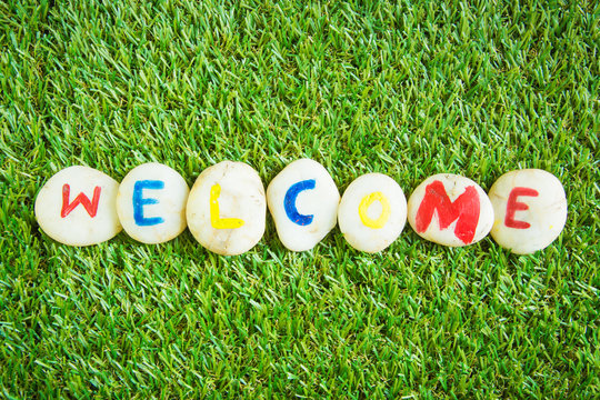 welcome paint on stone , on the grass