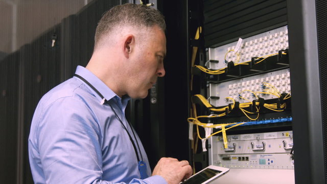 Technician using laptop to analyse server