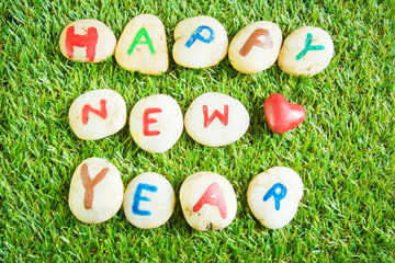 happy new year paint on stone , on the grass