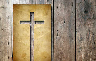Old vintage Christian paper cross on wood background