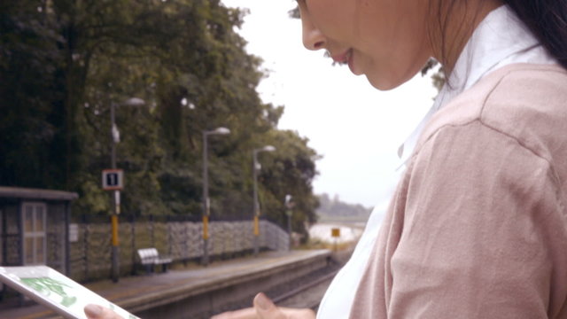 Businesswoman using tablet on train platform