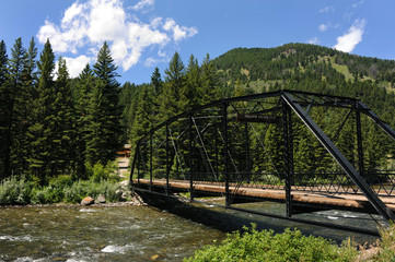 This Bridge leads home.  Black metal bridge spans the Gallatin River in the Gallatin River Valley, Montana.