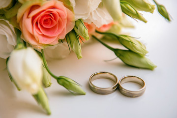 Obraz na płótnie Canvas Wedding rings near the bouquet