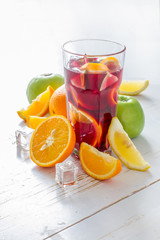 Sangria and ingredients on white wood background