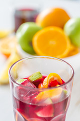 Sangria and ingredients on white wood background