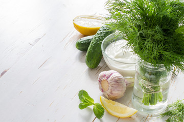 Tzatziki sauce ingredients, white wood background