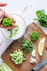 Tzatziki sauce ingredients, white wood background