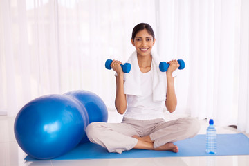Fototapeta na wymiar indian girl exercising with dumbbells