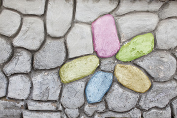 stone cladding wall with floral pattern. on a gray stone background painted colorful flower