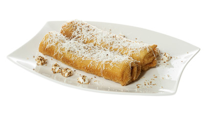 Two pancakes with savory filling served on a white plate with feta and sesame. Isolated on white.