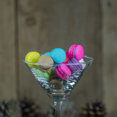colorful macaroons in glass on wooden table