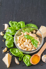 Pesto and ingredients an dark stone background