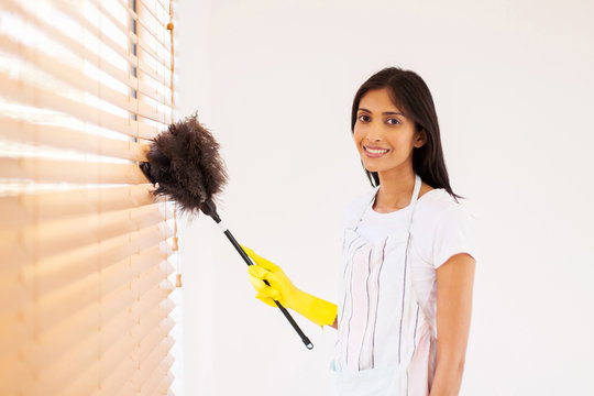 Young Indian Woman Cleaning Window Blinds
