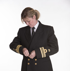 Female naval officer getting dressed into uniform jacket