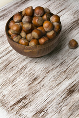 hazelnuts in wooden bowl on rustic background