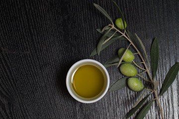 Branch of olive tree with green olive berries and cap of fresh o