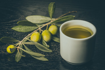 Branch of olive tree with green olive berries and cap of fresh o