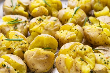 Rosemary roasted potatoes with garlic and sea salt on baking tray, close up. Cooked side dish for Thanksgiving table