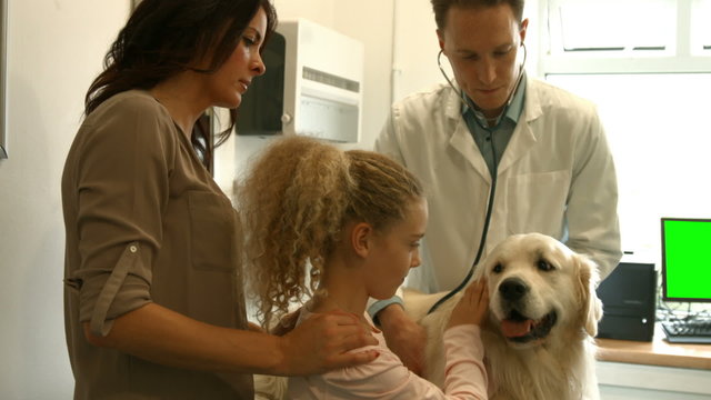 Mother and daughter with dog in the vets