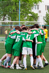 Members of the football team embrace after winning the match. Am