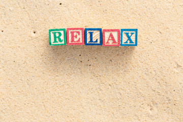 Obraz premium word RELAX in colorful alphabet blocks on tropical beach