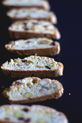 Biscotti pieces organized on dark background. Selective focus.