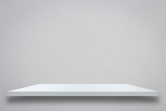 Empty top of white wooden shelf on grey cement wall © SKT Studio